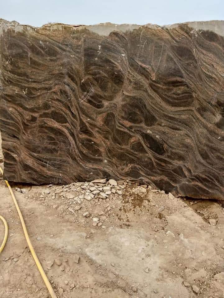 Vertical granite slab outdoors in stone yard